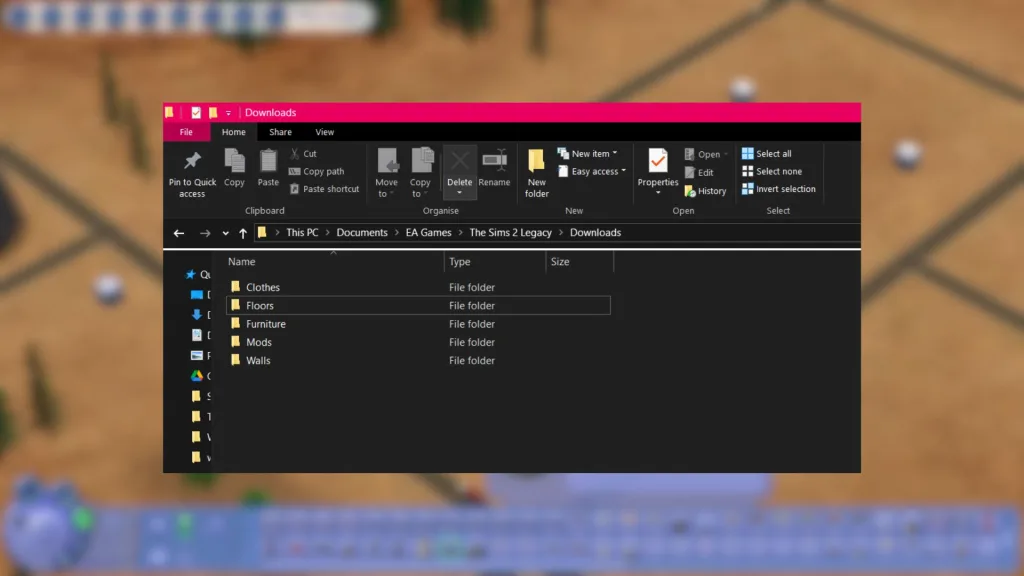 A screenshot of an organised mods and custom content (CC) folder in The Sims 2 with a blurry neighbourhood in the background.