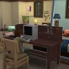 A Sim child playing on a desktop PC in a house in The Sims 4: Snowy Escape.