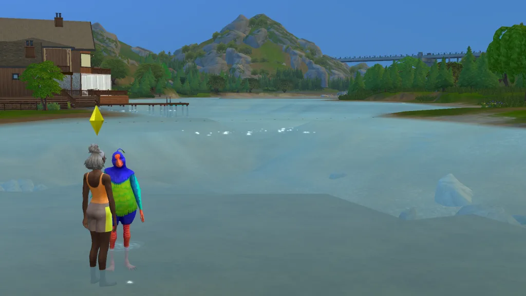 A human Sim talking to Plumbella the Plumbird in the river in Gibbi Point, with blue waters, trees, ad a pier behind them. They're on the riverbank.