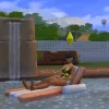 A Sim relaxing on a floatie in a large swimming pool in Tartosa on a getaway, with diving equipment and a hot air balloon behind them.